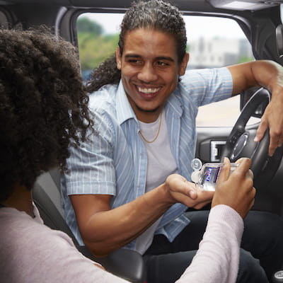 Man and woman using PURELL PRIME DEFENSE Advanced Hand Sanitizer in car