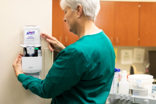 nurse changing refill on PURELL dispenser