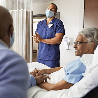 Healthcare worker using PURELL hand sanitizer at patient bedside