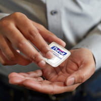 Man cracking PURELL Personal Size into palm of hand