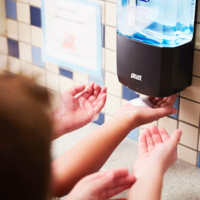 School children reaching for PURELL soap dispensers at sink